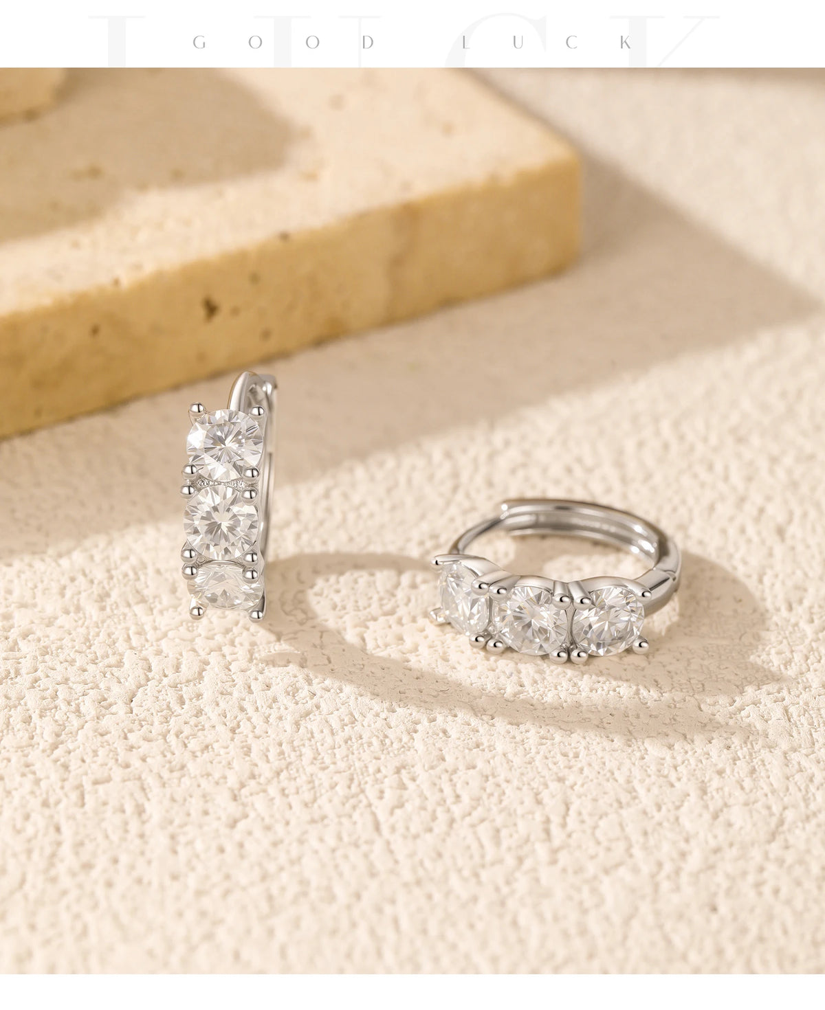 Round Moissanite Huggie Hoop Earrings in Sterling Silver — Pair on stone display