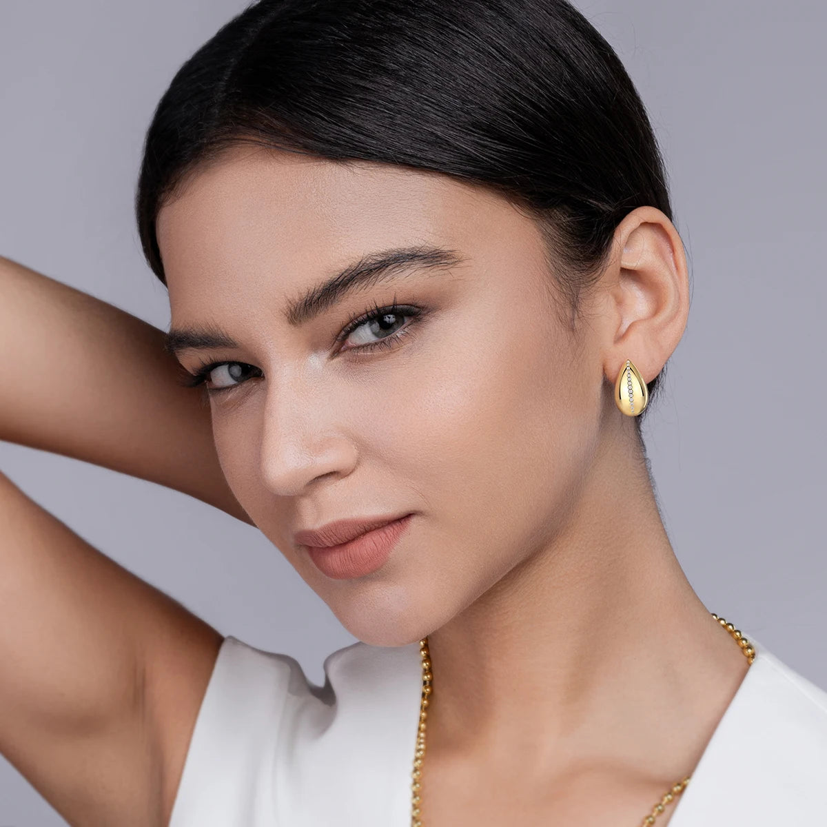 Gold-Plated Teardrop Moissanite Accent Stud Earrings — Gold-tone teardrops worn