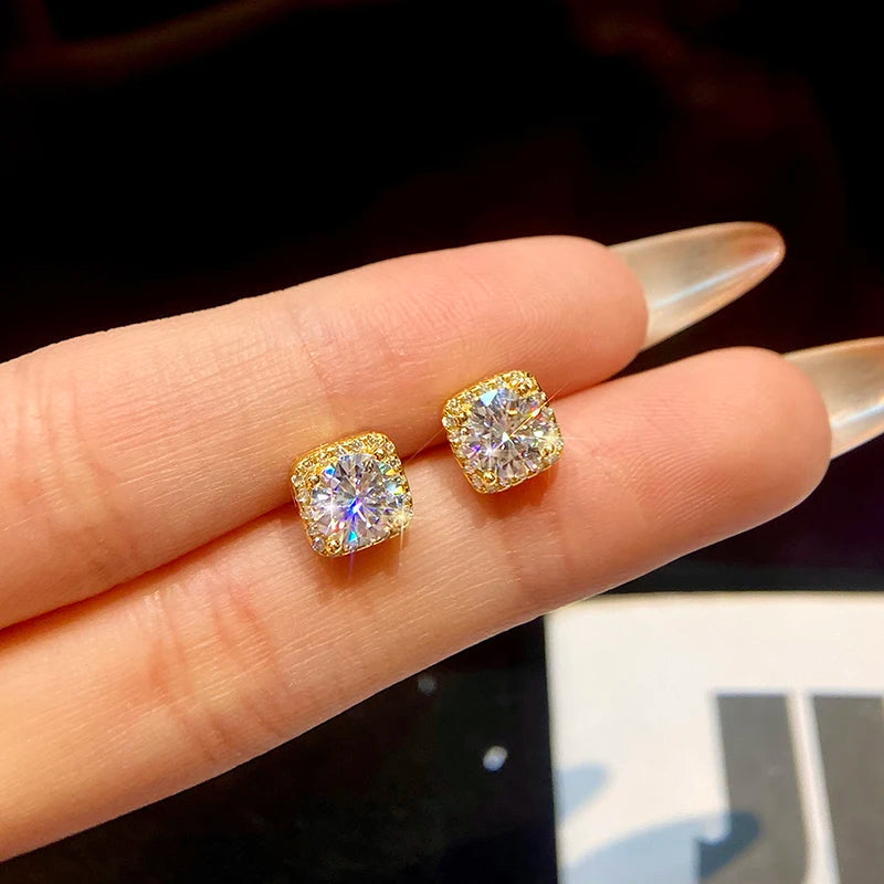 Round Moissanite Square Halo Stud Earrings in Silver — Gold-tone studs on hand