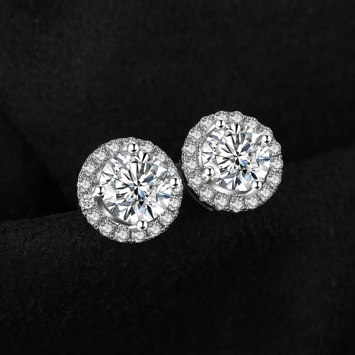 Round Moissanite Halo Stud Earrings in Plated Silver — Pair on dark surface