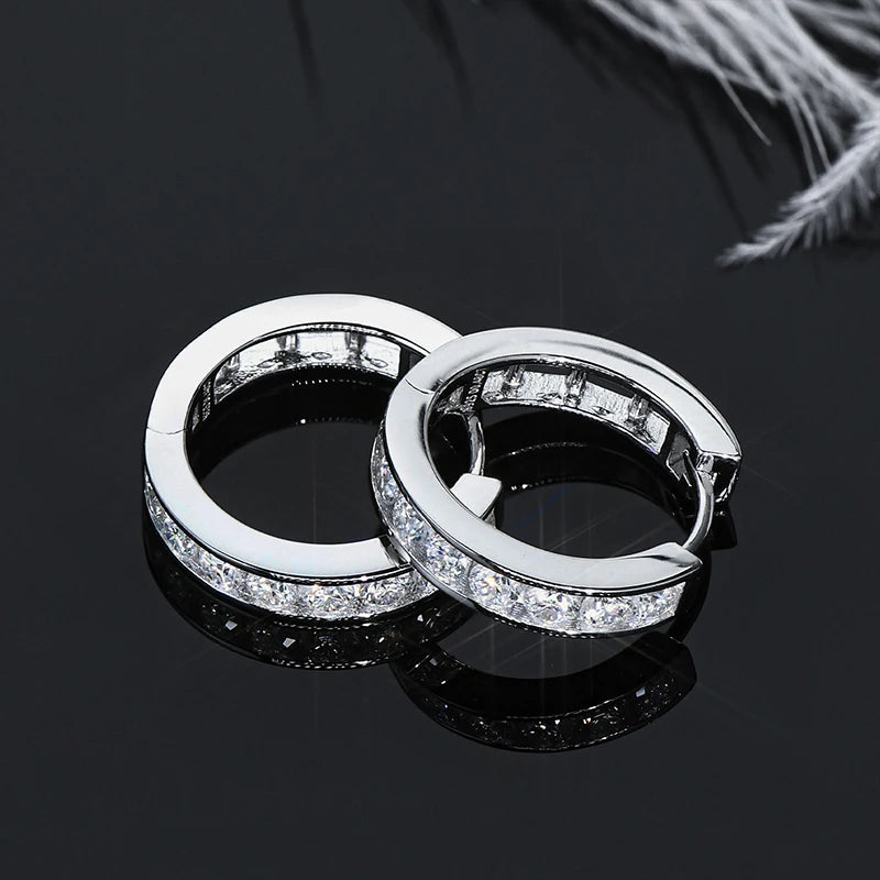 Moissanite Channel-Style Huggie Hoop Earrings in Silver — Silver hoops on reflective surface