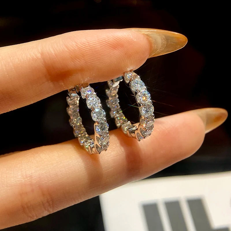 Round Moissanite Hoop Earrings in White Gold-Plated Silver — Hoop side profile on hand