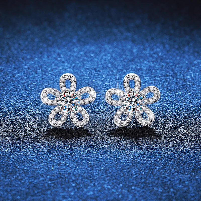 Five-Petal Flower Moissanite Stud Earrings in Silver — Pair on blue surface