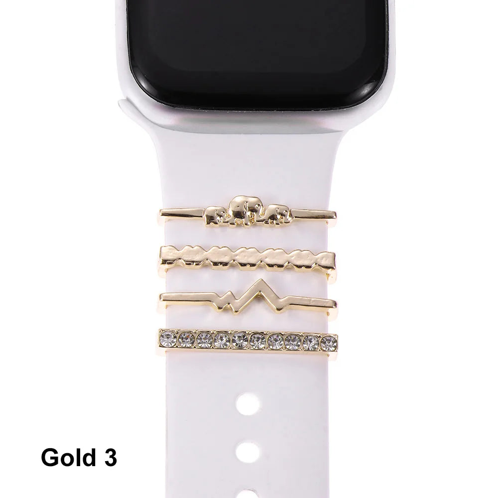 Decorative metal charms for Apple Watch bands in gold, elegantly enhancing a white smartwatch strap.