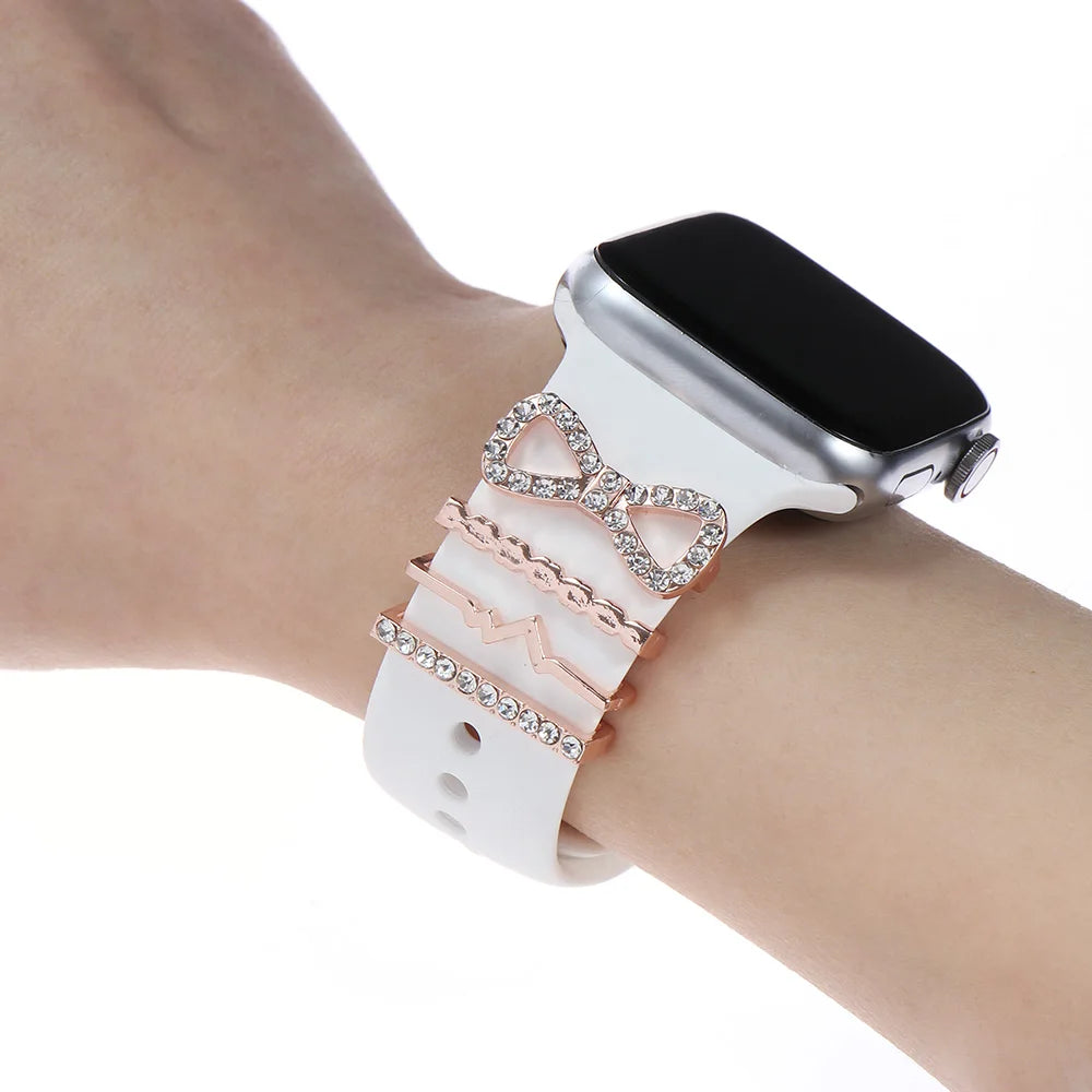 Decorative metal charms on a white Apple Watch band, adding elegance and style to a smartwatch.