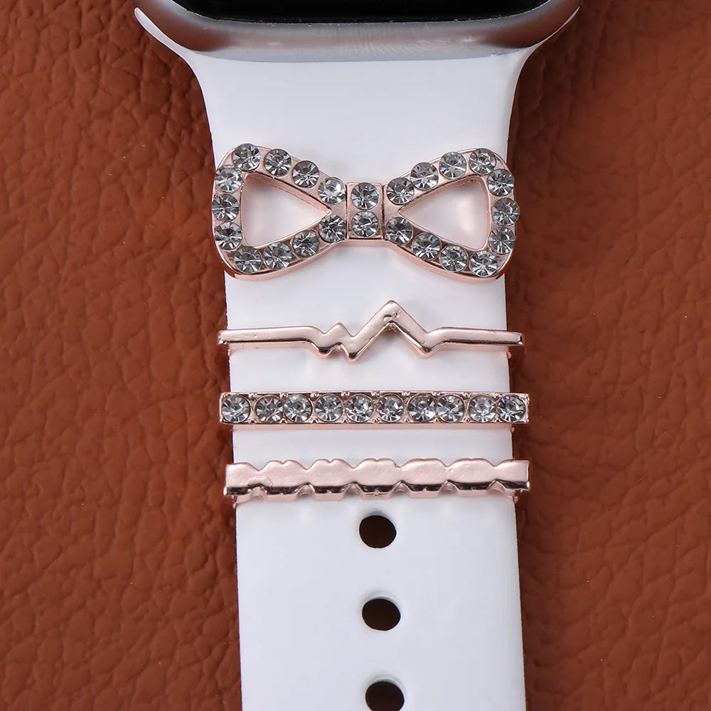 Decorative metal charms on a white Apple Watch band, enhancing style with elegant designs and sparkling details.