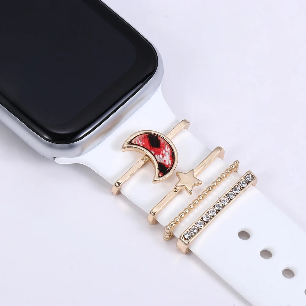 Decorative metal charms on white Apple Watch band featuring moon and star designs for personalized style.