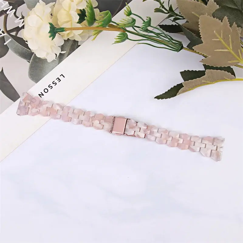 Pink marbled resin strap laid flat