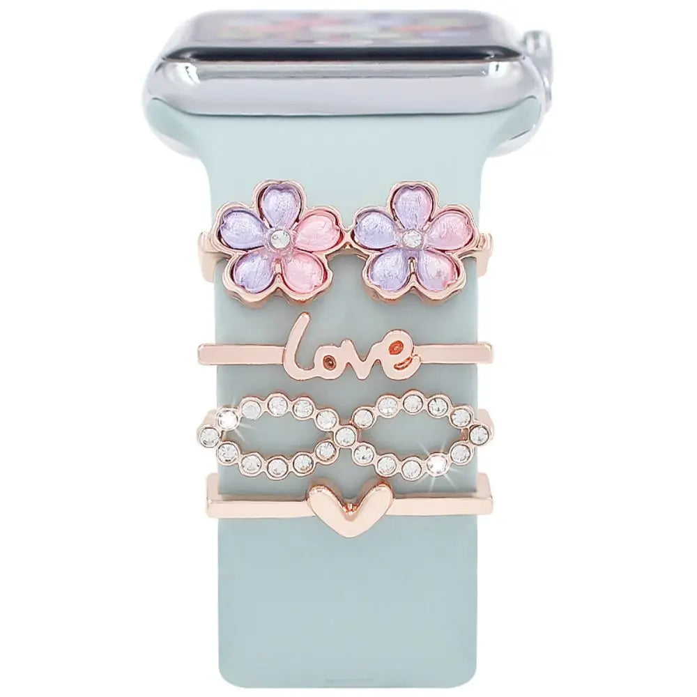 Decorative metal charms for Apple Watch bands featuring flowers, 'love', and heart designs in rose gold.
