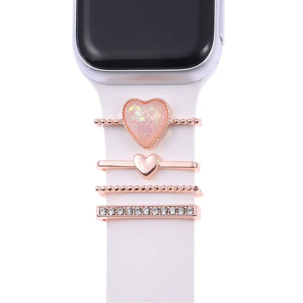 Decorative metal charms for Apple Watch bands in rose gold, featuring heart shapes and sparkling accents.