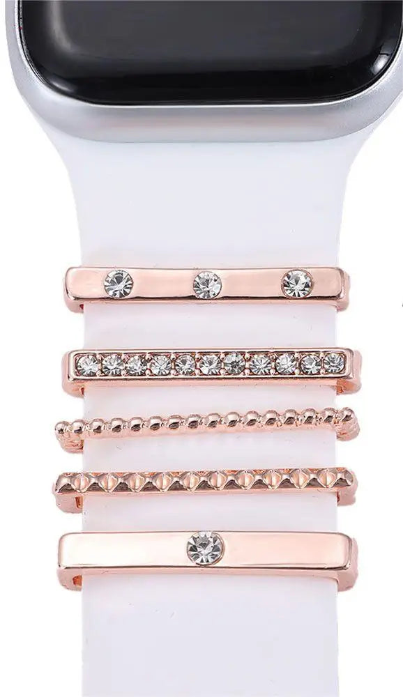 Decorative metal charms on a white Apple Watch band, offering a stylish and elegant upgrade for your smartwatch.