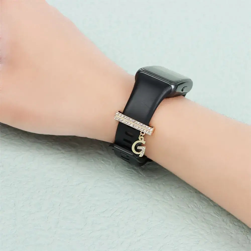 Decorative letter charm on a black Apple Watch band, showcasing luxury and style in smartwatch accessories.