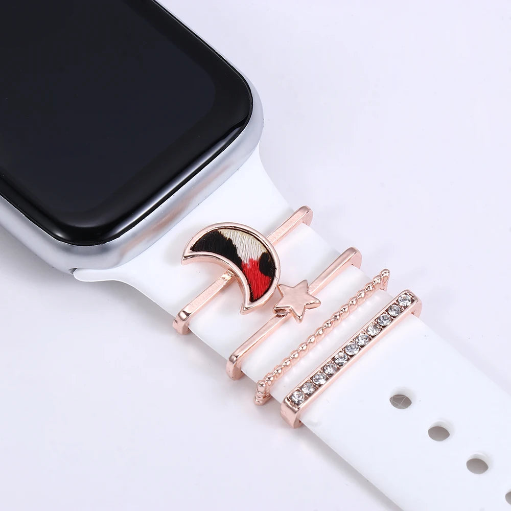 Decorative metal charms on white Apple Watch band featuring moon and star designs for added elegance.