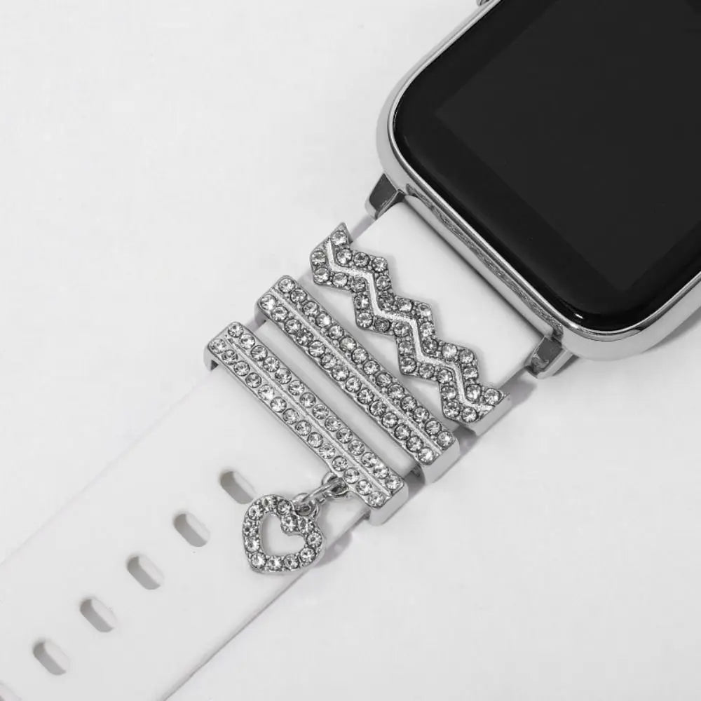 Decorative metal charms on a white Apple Watch band, showcasing elegant design and stylish embellishments.