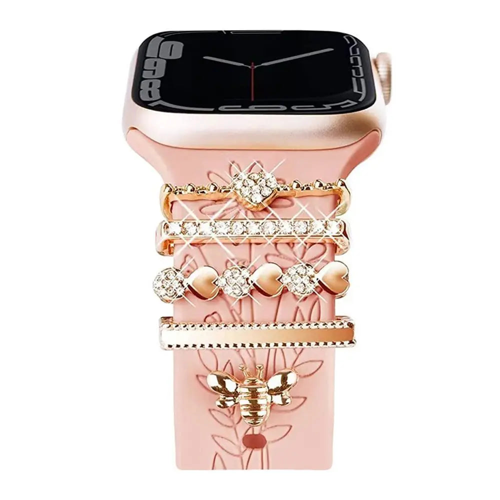 Decorative metal charms on a pink Apple Watch band, adding elegance and style to smartwatch accessories.