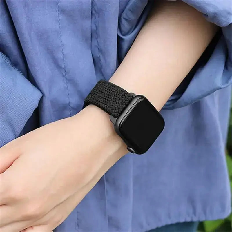 Black braided nylon Apple Watch band worn on wrist