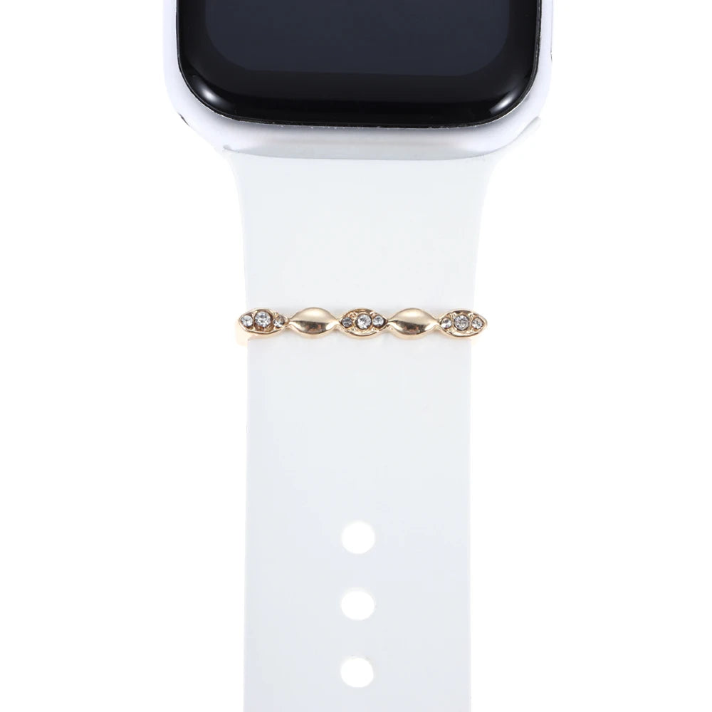 Decorative metal charm on white Apple Watch band adds elegance and style, perfect for personalizing your smartwatch.