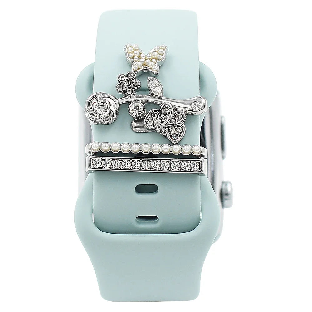 Decorative metal charms on a light blue Apple Watch band, adding elegance and personality.
