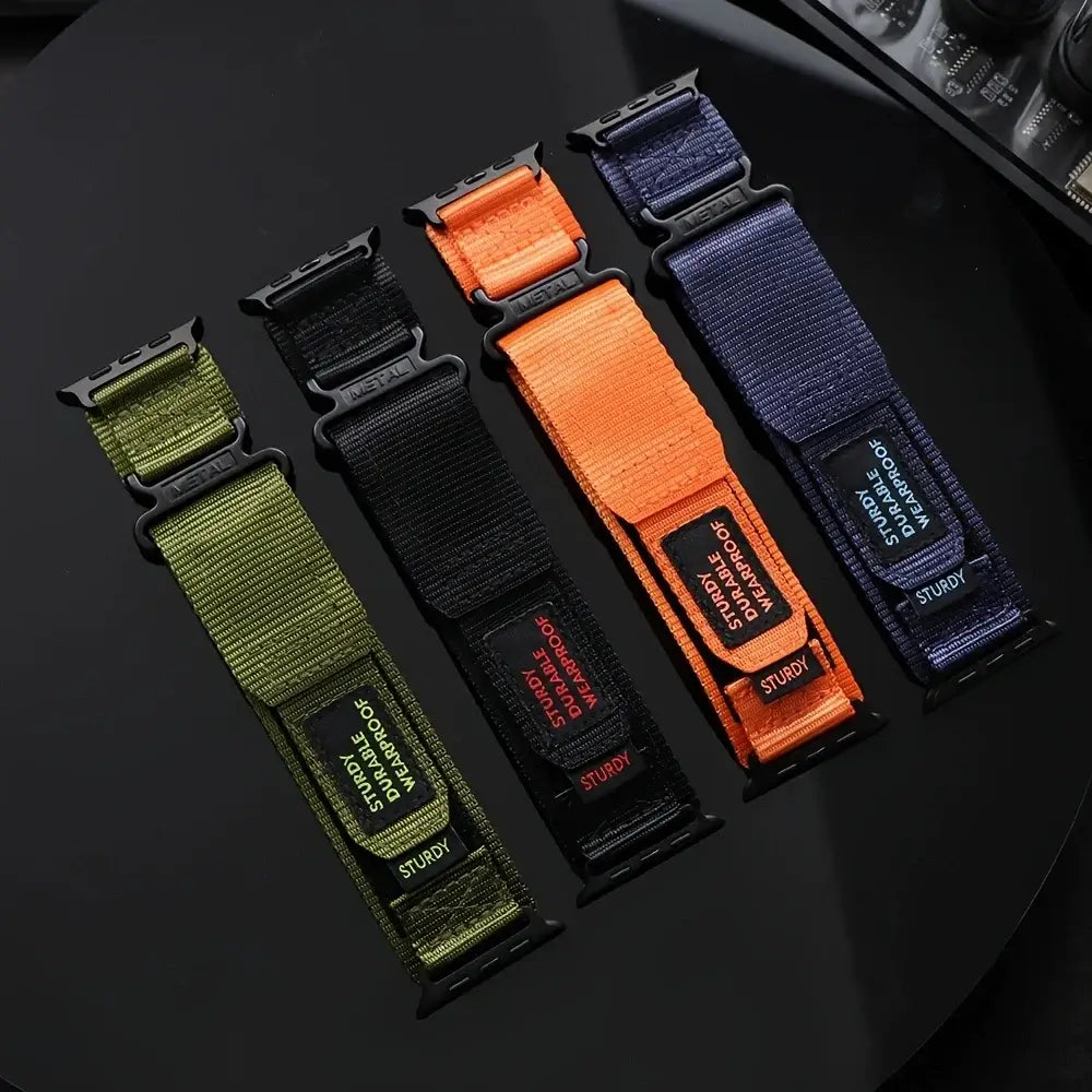 Olive, black, orange and navy utility nylon Apple Watch straps laid flat