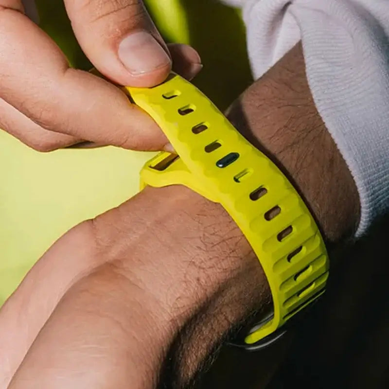 Close-up of fastening a neon yellow silicone Apple Watch strap