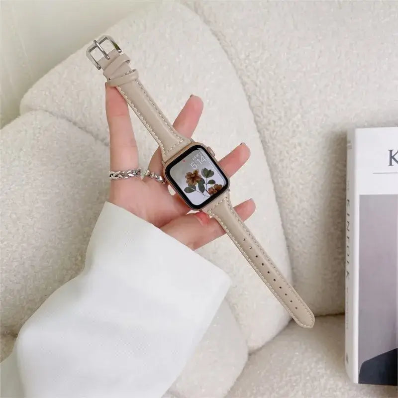 Beige stitched leather Apple Watch band held in hand