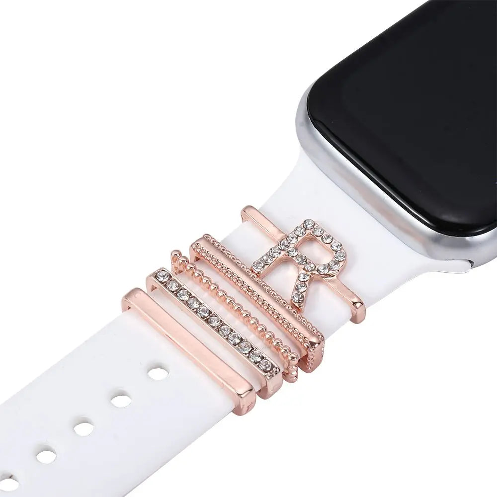 Decorative metal charms on a white Apple Watch band, adding elegance and personality to the smartwatch.