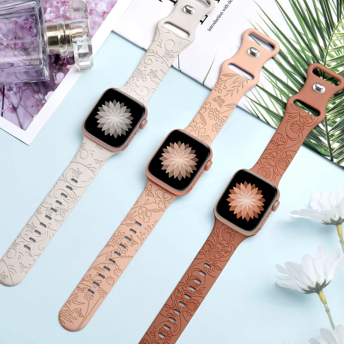 Three engraved botanical bands displayed flat for Apple Watch