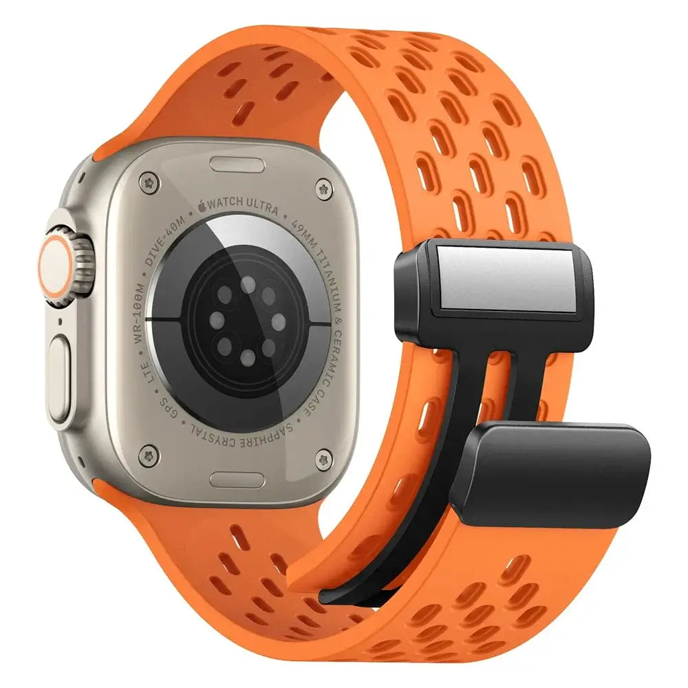 Orange perforated silicone band showing magnetic clasp and watch underside