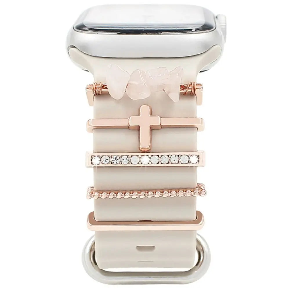 Stylish decorative metal charms on a pink Apple Watch band, enhancing its elegance and personalization.