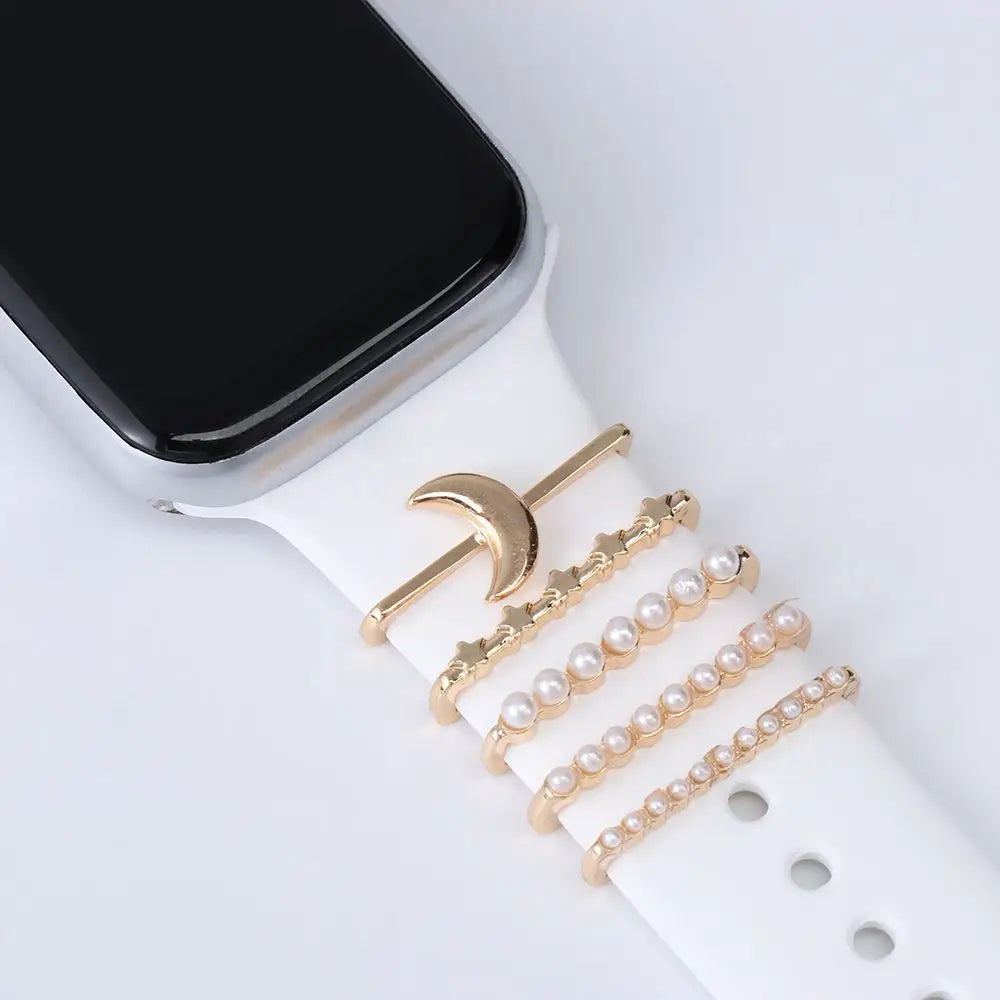 Decorative metal charms on a white Apple Watch band, adding elegance and personality to the smartwatch.