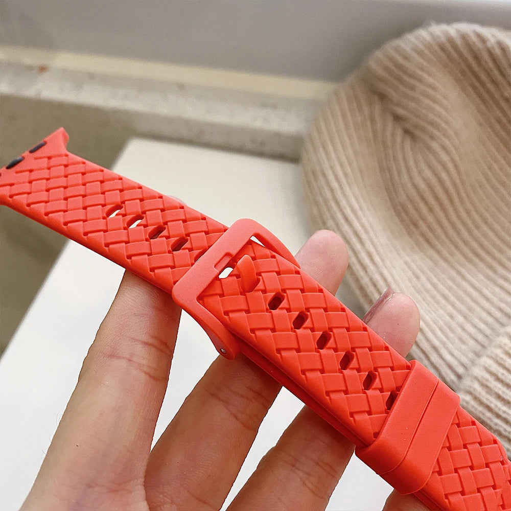 Close-up of red-orange basketweave pattern and buckle for Apple Watch