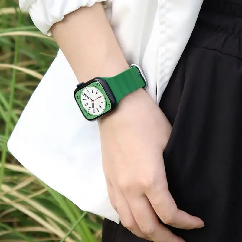 Green tubular silicone Apple Watch band worn on wrist