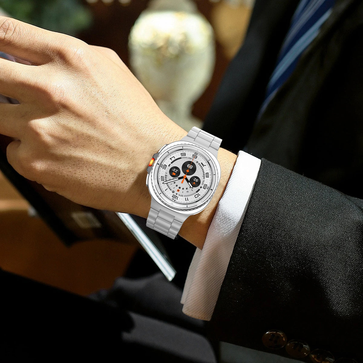 Silver steel link band worn with a suit