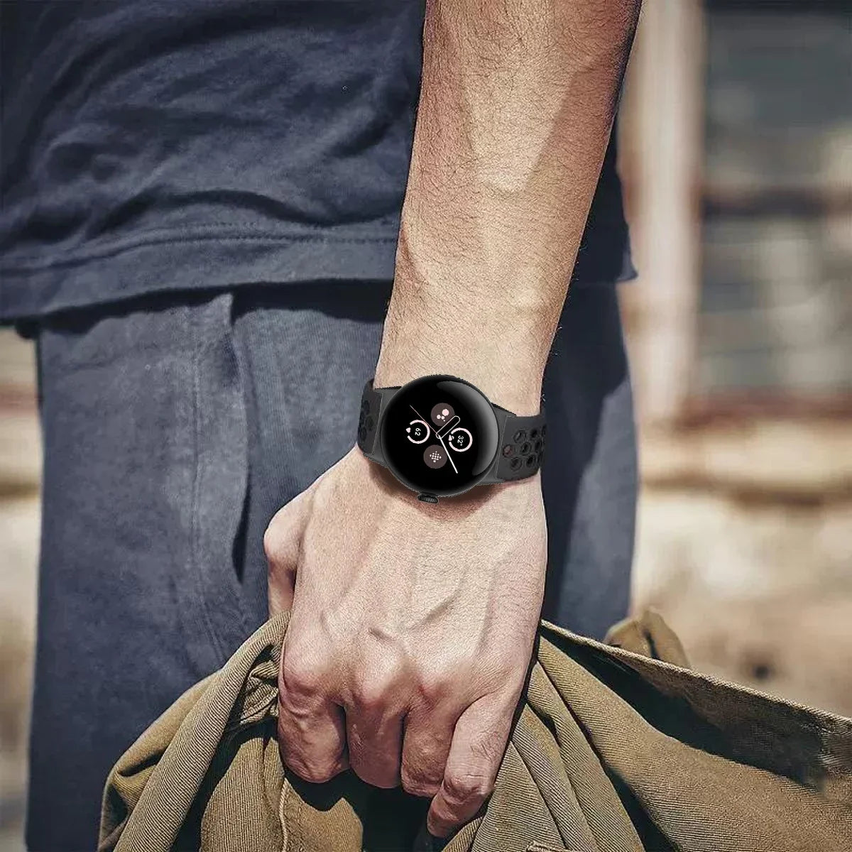 Dark perforated Pixel Watch band worn on wrist