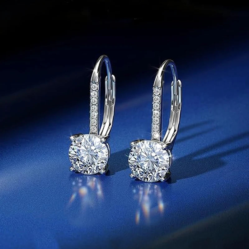 Moissanite Leverback Drop Earrings in Sterling Silver — Silver drops on blue surface