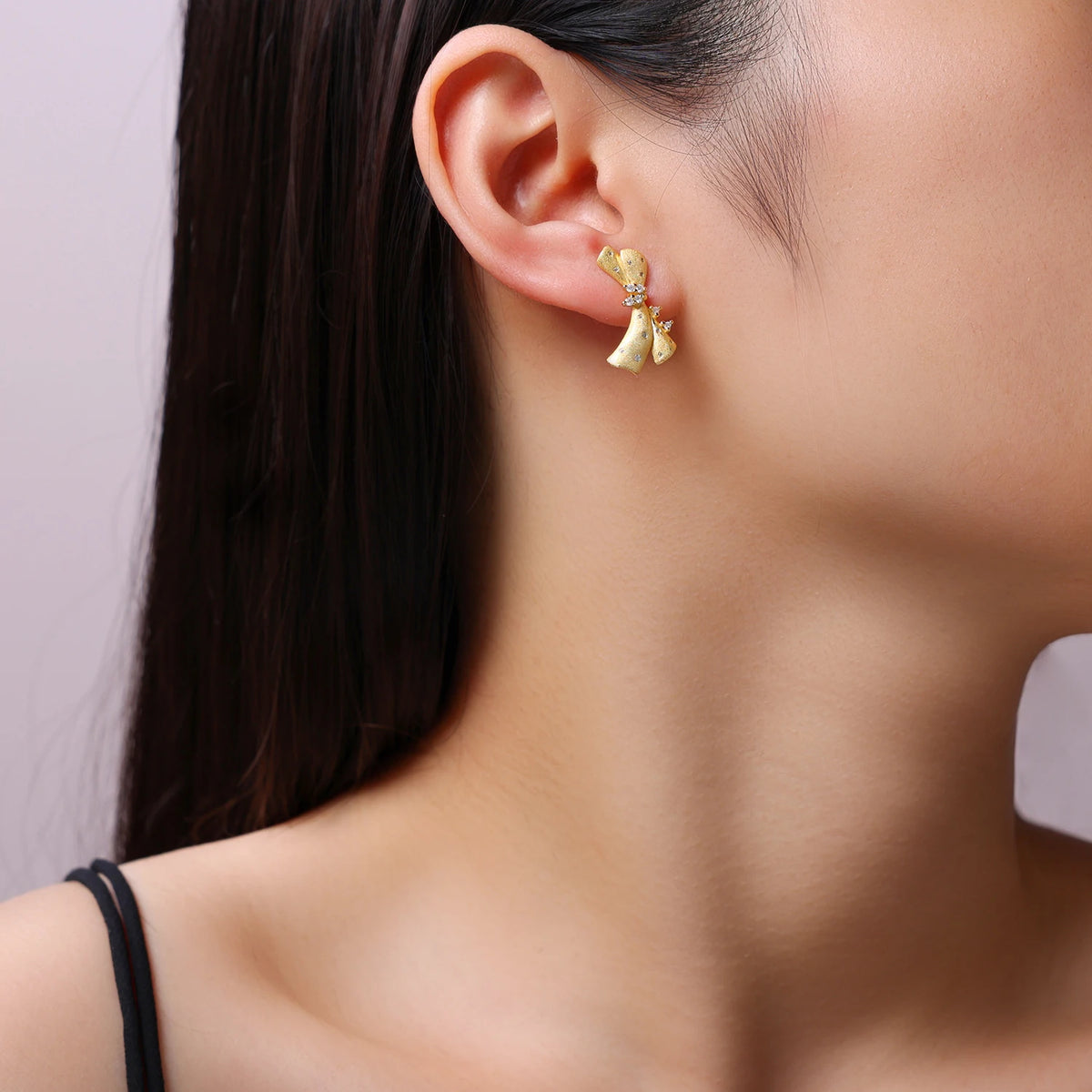 Gold-Plated Moissanite Ribbon Bow Stud Earrings — Gold bow earring worn on ear — BandsCo Straps