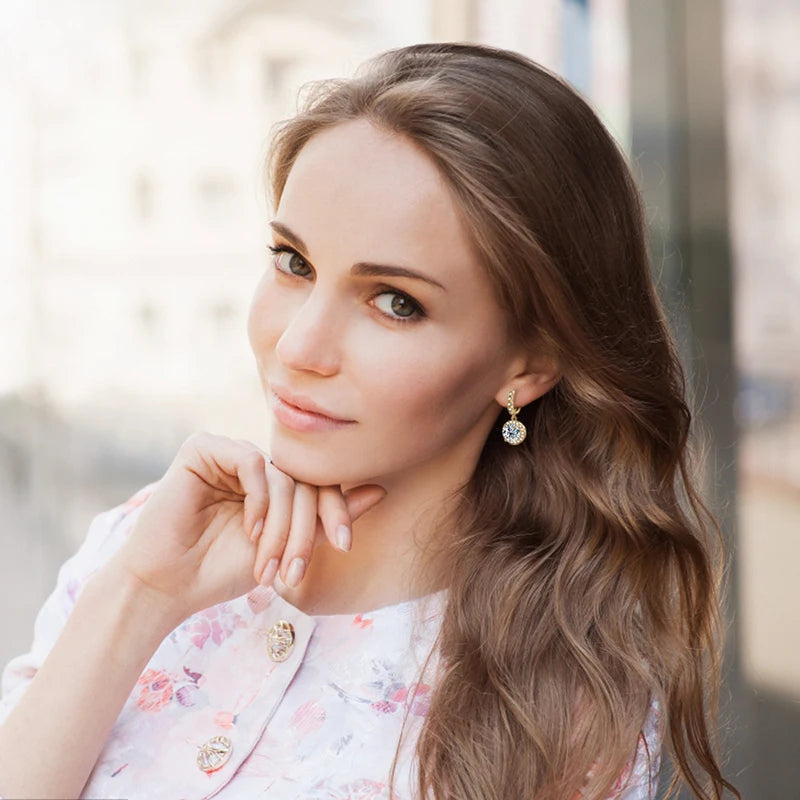 Round Halo Moissanite Huggie Drop Earrings in Sterling Silver — Shown on ear