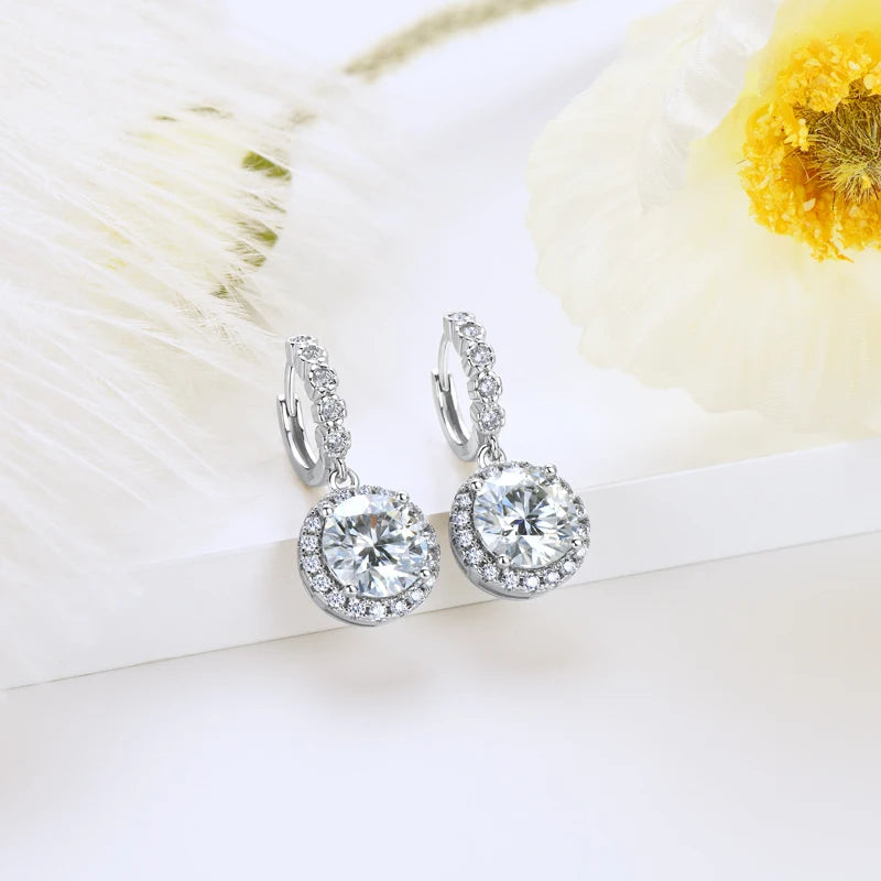 Round Halo Moissanite Huggie Drop Earrings in Sterling Silver — Silver pair on fabric
