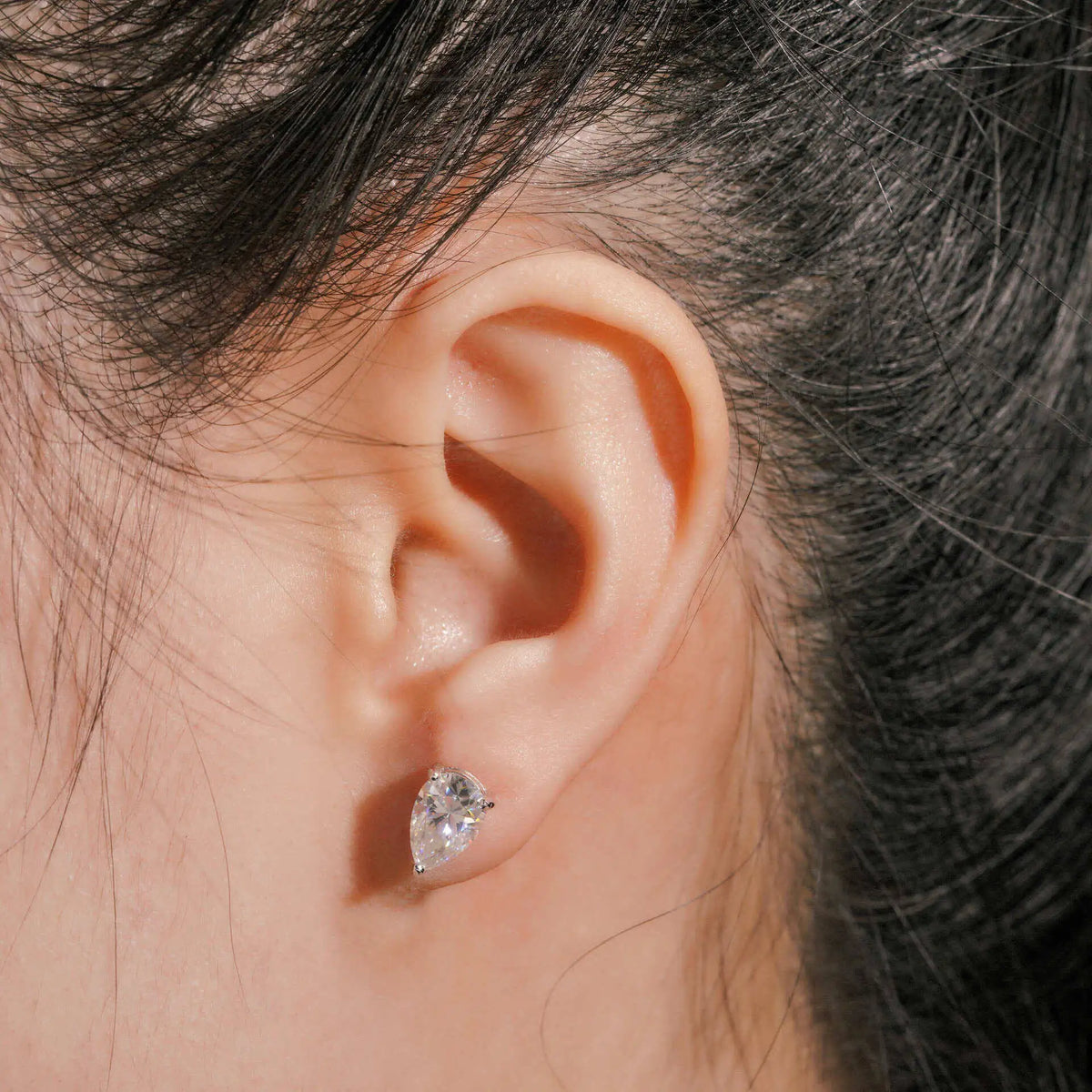 Pear Moissanite Solitaire Stud Earrings in Sterling Silver — Pear stud worn on ear — BandsCo Straps