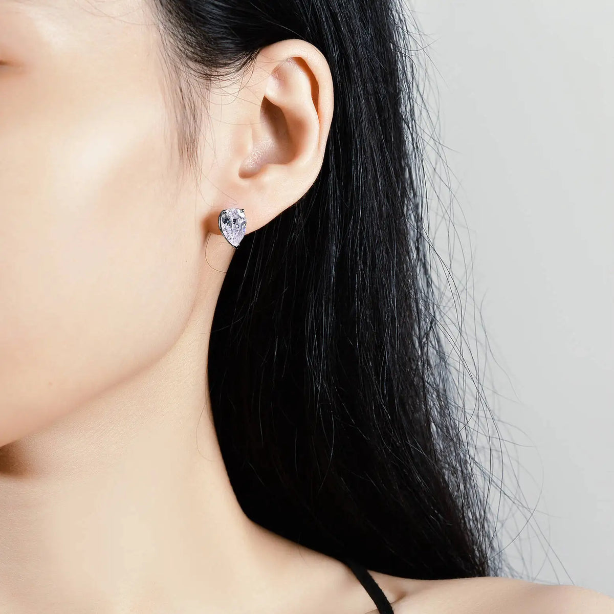Pear Moissanite Solitaire Stud Earrings in Sterling Silver — Pear solitaire on ear — BandsCo Straps