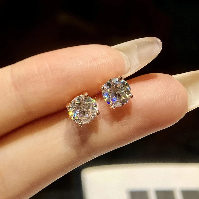 Black & White Moissanite Four-Prong Stud Earrings - white pair held for scale