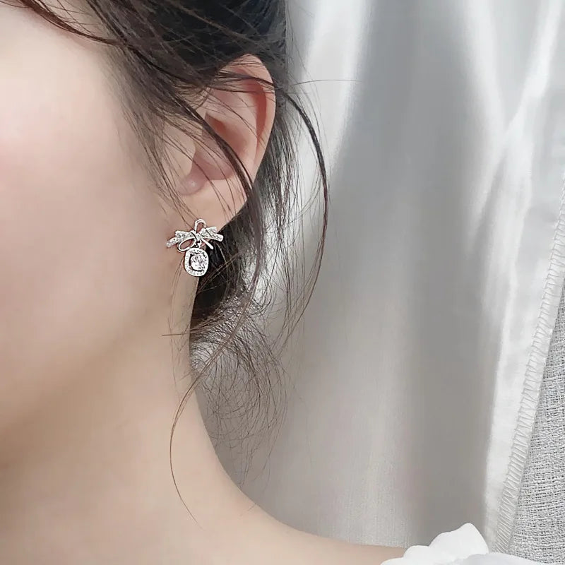 Moissanite Bow Stud and Drop Earrings in Sterling Silver — Halo bow drops worn on ear — BandsCo Straps