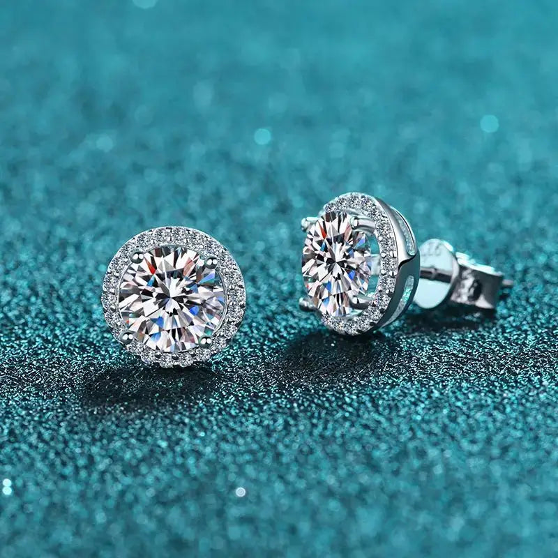 Round Halo Moissanite Stud Earrings in Sterling Silver - halo studs on blue fabric