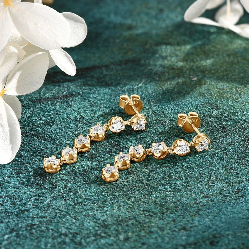 Six-Stone Moissanite Line Drop Earrings in Sterling Silver — Gold-Tone pair laid flat