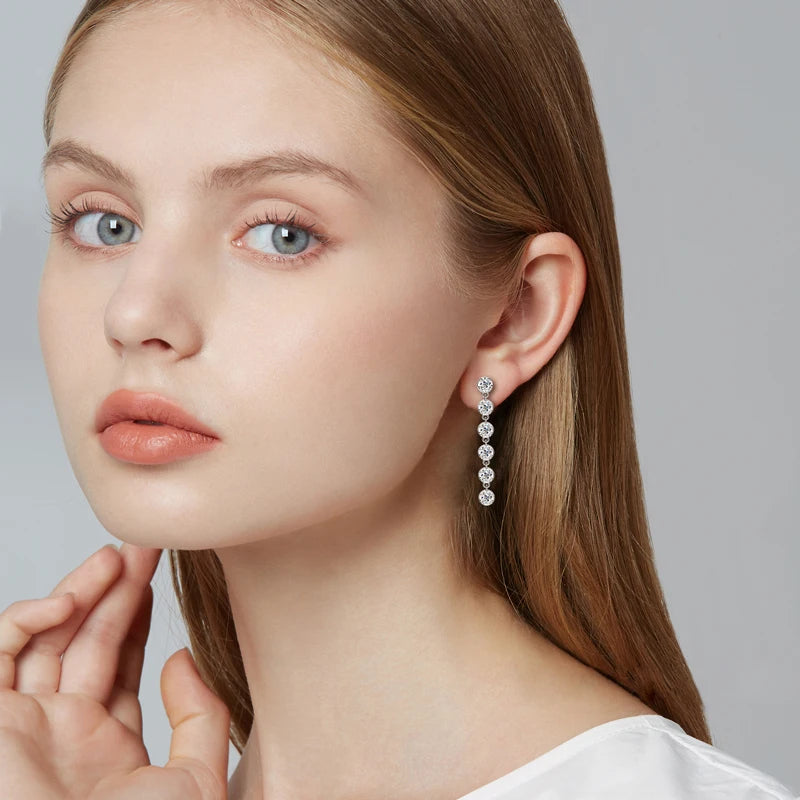 Six-Stone Moissanite Line Drop Earrings in Sterling Silver — Silver drops styled on the ear